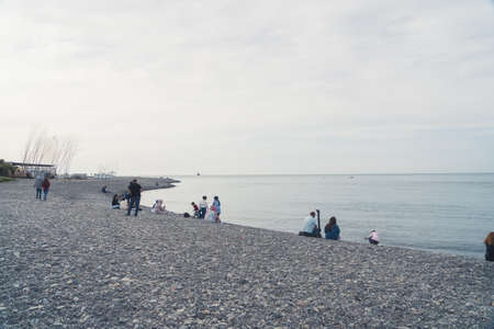 05.14.2022 - Batumi, Georgia people sitting on the Black Sea beach in the cloudy weather, Batumi, Adjara, Georgia. High quality photoのeditorial素材