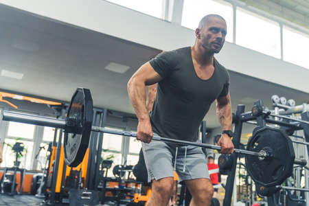 Handsome sporty Man exercising with weight plate in gym . High quality photoの写真素材