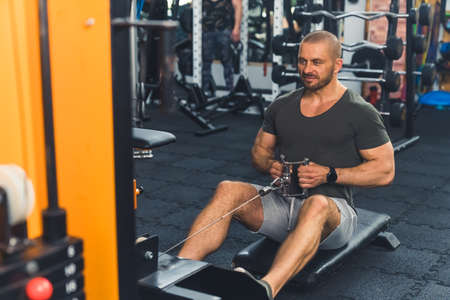 Healthy life and gym exercise concept. Fit man working out in sport fitness club. High quality photo