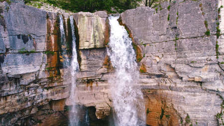 Ascending shot of two streams of the waterfall, aerial. High quality photo