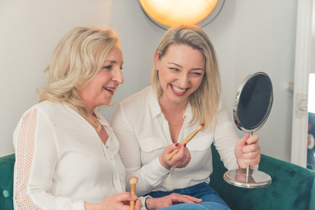 blonde Caucasian women doing make up in living room medium full shot indoors feminine concept. High quality photoの写真素材