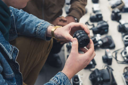 18.05.2022. Tbilisi, Georgia. a customer testing camera lenses at the flea market. High quality photoのeditorial素材
