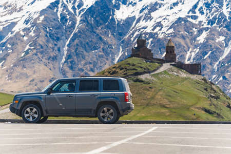 young woman enjoying the view of the Caucasus mountains in Kazbegi, Georgia. majestic Caucasus mountains and Gergeti Trinity Church. High quality photoの写真素材