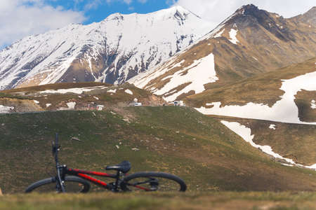 mountain bicycle on a beautiful mountains meadow with the snowcapped Caucasus Mountains in the background, Georgia. High quality photoの写真素材