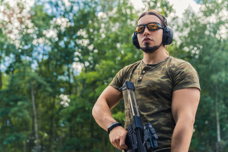 Medium outdoor shot of a military-looking caucasian muscular man in moro t-shirt looking far away at...