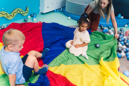 Happy toddlers having an active sensory play at the nursery school. Kids wellness. Early fine motor...