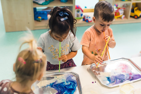 cute little children using creative art techniques for their painting, Ebru art. High quality photo