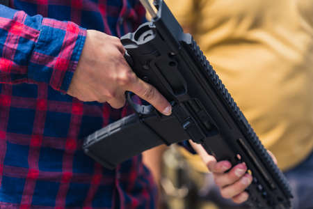 Close up of mans arms holding uzi gun. Firearm training. Horizontal outdoor shot. High quality photoの写真素材