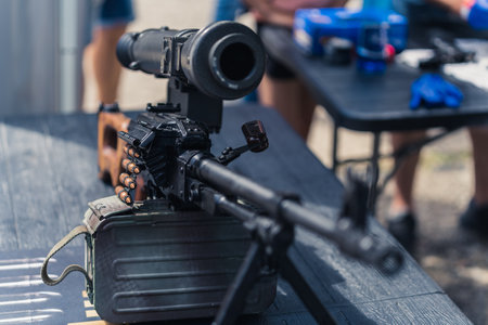 Close up front view of rifle gun scope and barrel standing on table at gunsmith workshop. Horizontal...