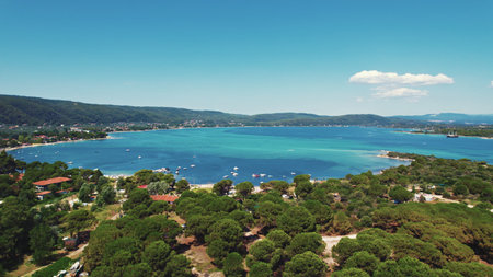 Beautiful turquoise water lagoon surrounded by land with trees and some summer houses. Aerial view. High quality photoの写真素材