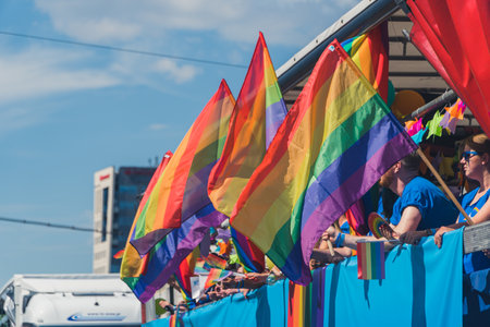 06.25.2022 Warsaw, Poland -Proud and cheerful LGBTQAI protesters waving their rainbow flags out of a parade bus balcony. Support and love concept. High quality photoのeditorial素材