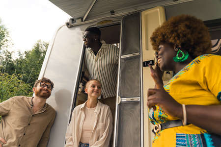 multiethnic friends near the van enjoying on a summer trip. High quality photo