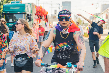 06.25.2022 Warsaw, Poland. Tattooed person riding a bike with a rainbow gay flag on their arms...