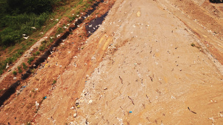 Creative shot of white birds, seagulls, flying underneath the done, and above the landfill. Human impact on natural environment. High quality photoの写真素材