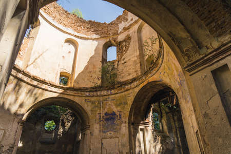 Interior of ruined abandoned church in Lubycza Krolewska. Archways arches and windows. Tower with no roof. Faded frescos. Horizontal shot. High quality photoの写真素材