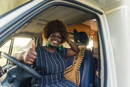 happy Afro-American woman sitting at the steering wheel and showing okay sign. High quality photoの写真素材