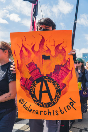 June 25, 2022 Warsaw, Poland - Pride parade in Warsaw, Poland. A man in a crowd holding a powerful protest signs in support of Belarus nation. High quality photoのeditorial素材