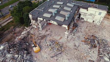 06.08.2022 - Warsaw, Poland - The demolition site. The excavator crusher destroying a huge old building. Freeing up space for the construction of a new one. High quality photoのeditorial素材