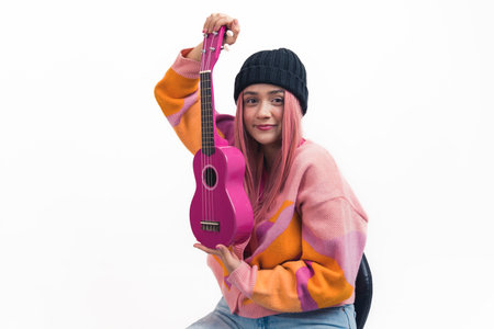 White teenage girl with pink long hair wearing colorful sweater sitting in chair showing pink...