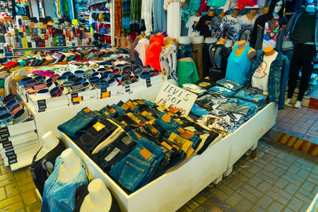 10.11.2022 Manavgat, Turkey - Bazaar. Jeans shirts and other various clothes displayed at clothing store stall at Turkish bazaar. Horizontal shot. High quality photoのeditorial素材