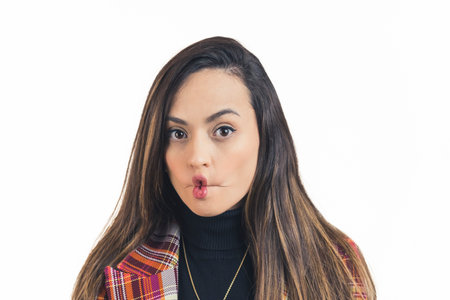 closeup shot of brunette girl making her lips bow like a fish and posing, white background studio...