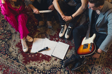 high-angle shot of a music band sitting on the carpet and thinking about a new song, guitarists, a drummer and a soloist. High quality photoの写真素材