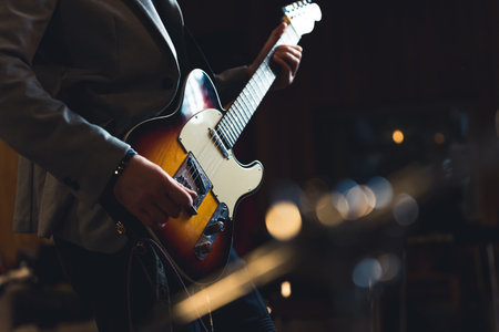 Cropped shot of guitarist holding electric guitar. Indoor shot of unrecognizable caucasian guitarist in a blazer holding professional guitar. High quality photoの写真素材