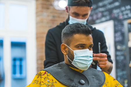 Two men wearing protective face masks at barbershop. High quality photoの写真素材