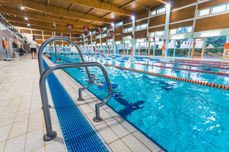 05.12.2022 Ozarow Mazowiecki, Poland - Mid shot of a swimming pool with a metal ladder on the front. High quality photoのeditorial素材