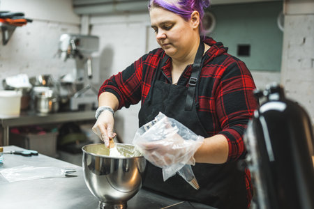 Person filling disposable pastry bag with buttercream frosting to decorate cupcakes and tarts....