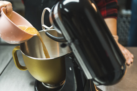 putting ingredients in a modern kitchen stand mixer to bake cakes, dessert concept. High quality photoの写真素材