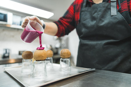 decorating chocolate balls with pink cream in the bakery, dessert concept. High quality photoの写真素材