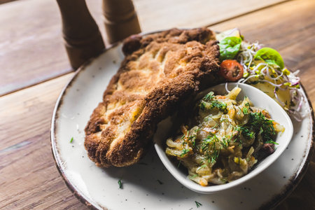 Top-down view of breaded fried pork cutlet schabowy with boiled potatoes and salad served on white plate. Polish cuisine. Horizontal indoor shot. High quality photoの写真素材
