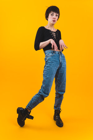 Full silhouette of young stylish person doin funny face and posture. Vertical full-length studio...