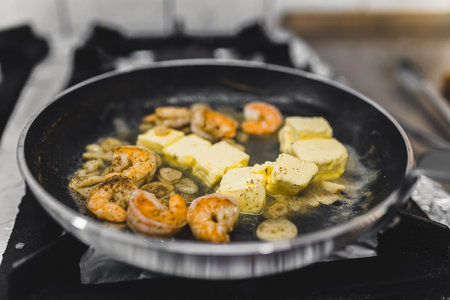 Shrimps fried in butter in frying pan for spicy chilli sauce dish. Restaurant kitchen food preparation process. Horizontal indoor shot. High quality photoの写真素材