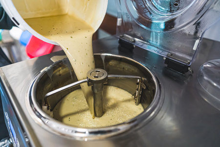 Pouring ice cream mix into a pasteurizing machine. High quality photoの写真素材