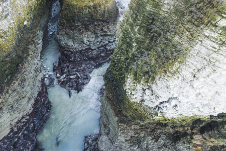 top-down view of water running through coastal chalk cliffs on Flamborough Head, Yorkshire. High...