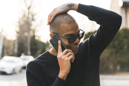 Surprised positive-looking young adult Black man having a phone call in the middle of the street and...