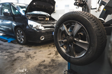 closeup shot of balancing the wheel in car service, car repair concept, a car in the background. High quality photoの写真素材