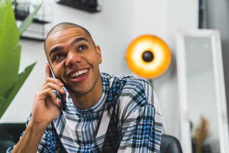 Portrait of smiling African American man on the phone call, indoor. High quality photoの写真素材