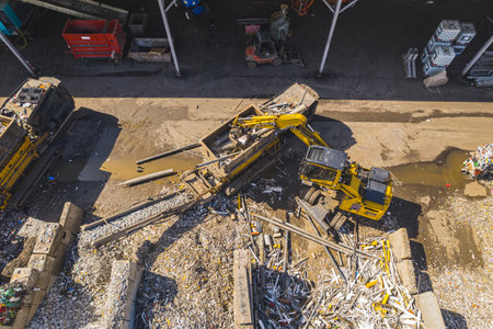 Excavator loading metal onto shredder machine for crushing the scrap and recycle, Netherlands. High quality photoの写真素材