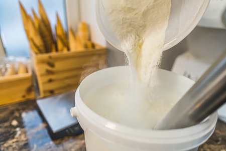 Chef adds sugar in a blender for preparing ice cream top view of kitchen counter. High quality photoの写真素材