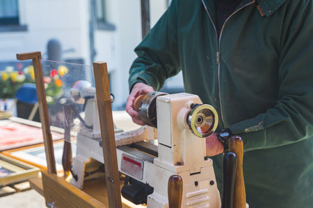 Dutch artist using professional wood-trimming machine at a market stall in Hillegom, town in the in the Western Netherlands. No face. High quality photoの写真素材