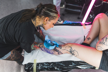 young tattoo artist drawing a tattoo with big enthusiasm in her art studio. High quality photoの写真素材