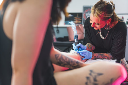 tattoo artist applying ink on a customers body, tattoo-making process. High quality photoの写真素材