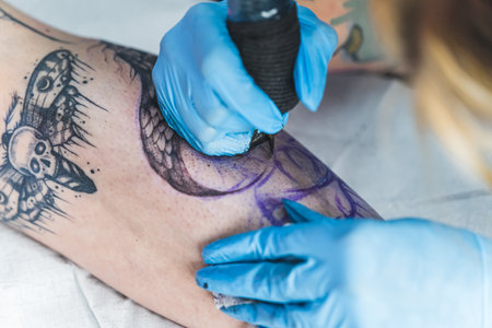 closeup shot of a tattoo master working on a new tattoo in the studio. High quality photoの写真素材
