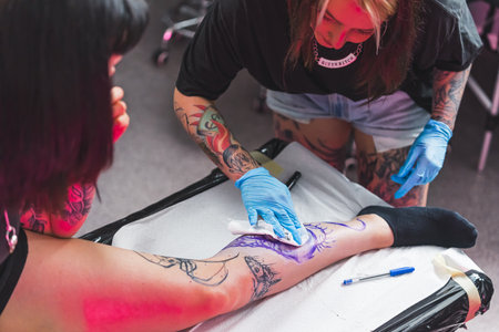 tattoo master cleaning marker-drawn figure, Freehand technique. High quality photoの写真素材