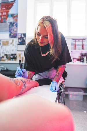 Freehand technique, drawing a pattern with a blue marker, vertical shot, tattoo studio. High quality photoの写真素材