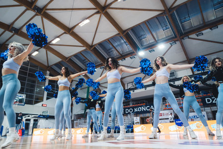 Young women dance team performing with pompons on court during basketball game. High quality photoの写真素材