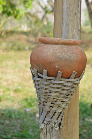 small pottery jar in bamboo handleの写真素材